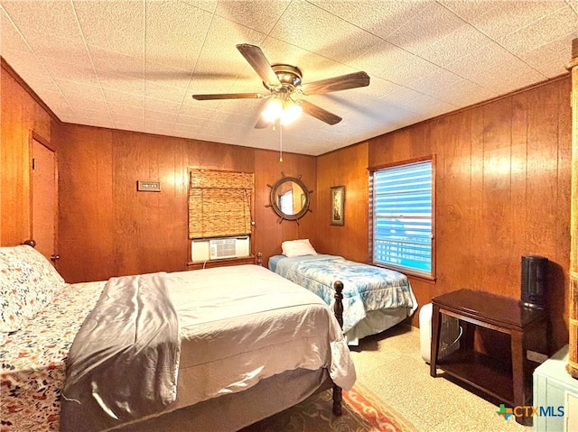 carpeted bedroom with ceiling fan, cooling unit, and wooden walls