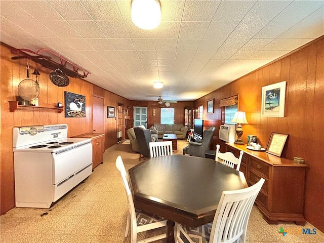 dining room with ceiling fan and wood walls