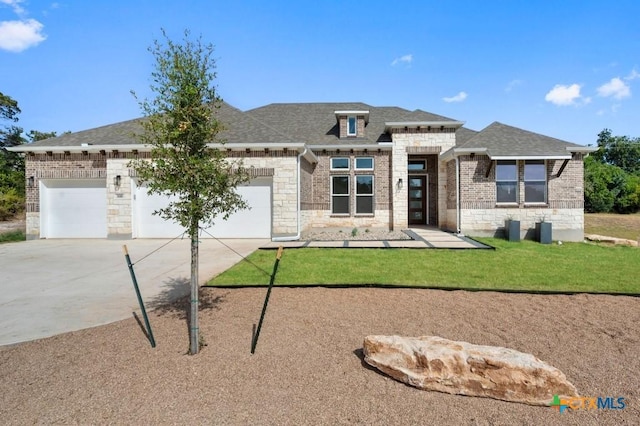 prairie-style house featuring a garage and a front lawn