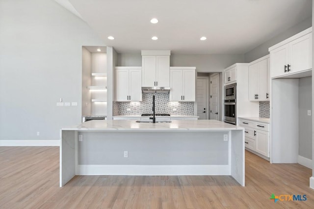 kitchen featuring a kitchen island with sink, white cabinets, light hardwood / wood-style floors, and appliances with stainless steel finishes