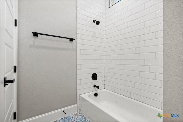 bathroom featuring tile patterned flooring and tiled shower / bath