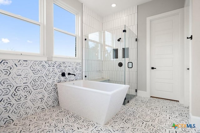 bathroom with tile patterned floors and independent shower and bath