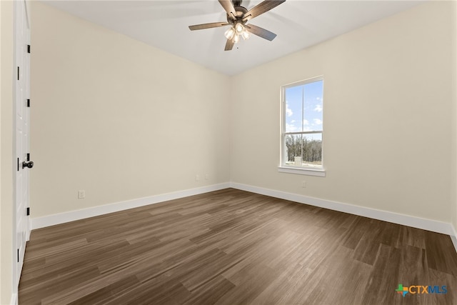 spare room with dark wood-style floors, ceiling fan, and baseboards