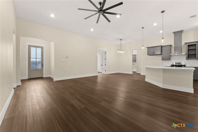 unfurnished living room with baseboards, dark wood finished floors, a ceiling fan, and recessed lighting