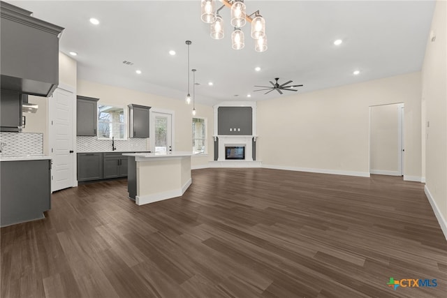 kitchen featuring a center island, pendant lighting, gray cabinets, light countertops, and open floor plan