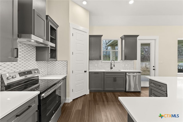 kitchen featuring stainless steel appliances, gray cabinets, light countertops, and a sink