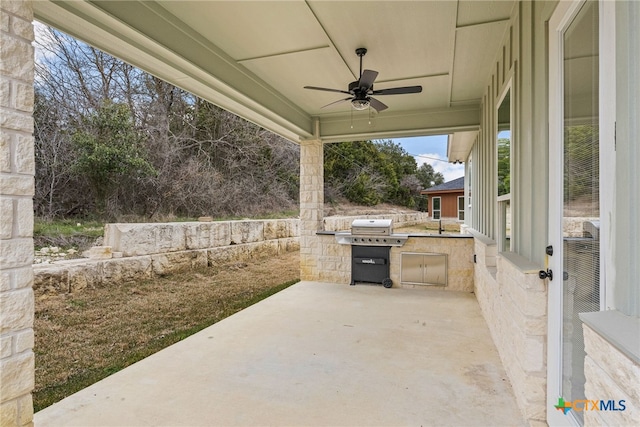 view of patio / terrace with exterior kitchen, a grill, and a ceiling fan