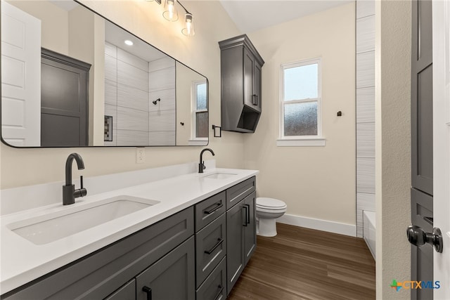 full bath featuring toilet, baseboards, a sink, and wood finished floors