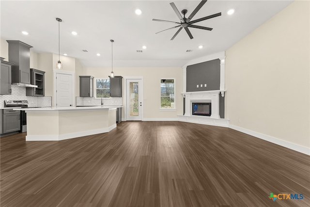 kitchen featuring a kitchen island, open floor plan, stainless steel electric stove, light countertops, and pendant lighting