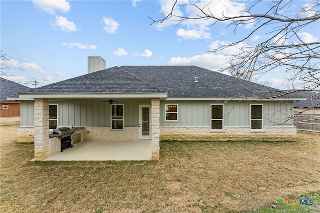 back of house featuring a patio, a chimney, roof with shingles, exterior kitchen, and board and batten siding