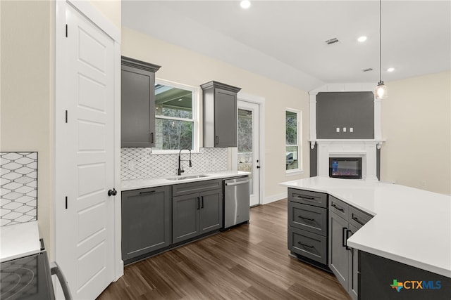 kitchen featuring stainless steel appliances, a sink, hanging light fixtures, light countertops, and gray cabinets