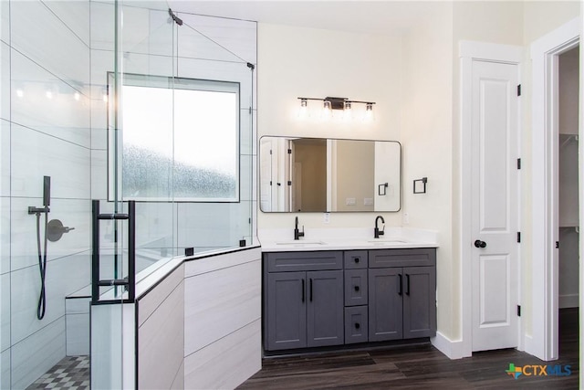 bathroom featuring tiled shower, hardwood / wood-style floors, and vanity