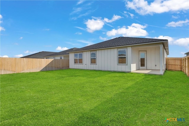 back of property with a yard and a patio