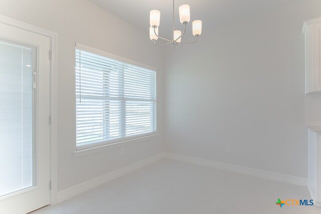 unfurnished dining area featuring a chandelier and a healthy amount of sunlight