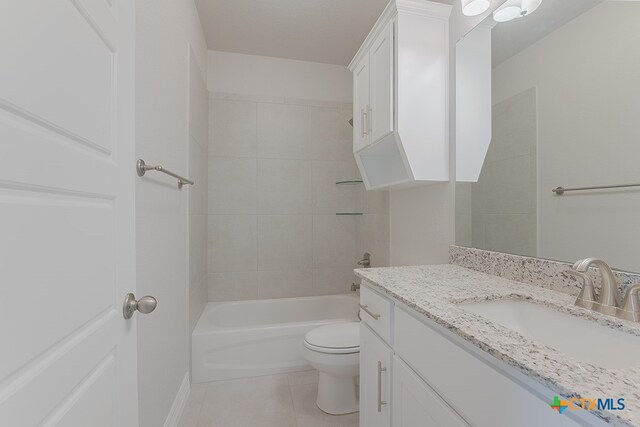 full bathroom with vanity, tile patterned flooring, toilet, and tiled shower / bath combo