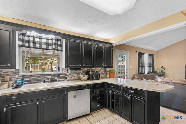 203 Yorkshire Ln, Victoria, TX 77904 - kitchen with stainless steel dishwasher, dark cabinets, open floor plan, decorative backsplash, and lofted ceiling