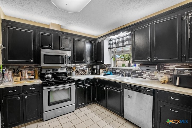 203 Yorkshire Ln, Victoria, TX 77904 - kitchen featuring appliances with stainless steel finishes, dark cabinets, and a textured ceiling
