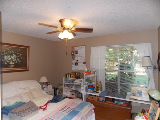 bedroom with a textured ceiling and a ceiling fan