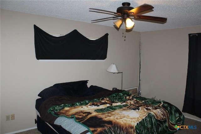 bedroom featuring a textured ceiling, ceiling fan, and carpet