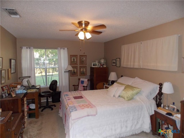 bedroom featuring light carpet, visible vents, a textured ceiling, and ceiling fan