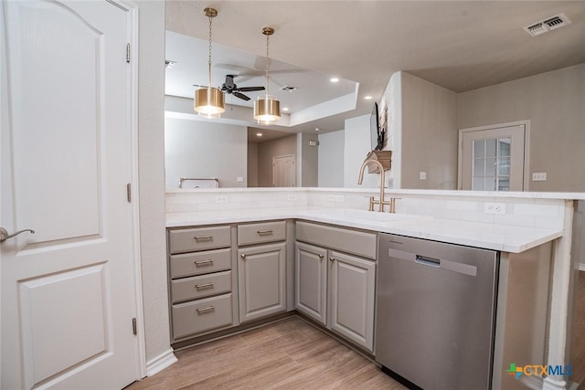 kitchen featuring visible vents, gray cabinetry, a sink, stainless steel dishwasher, and light wood finished floors