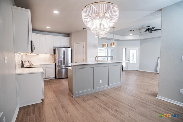 kitchen with light countertops, light wood-style flooring, white cabinets, and stainless steel appliances