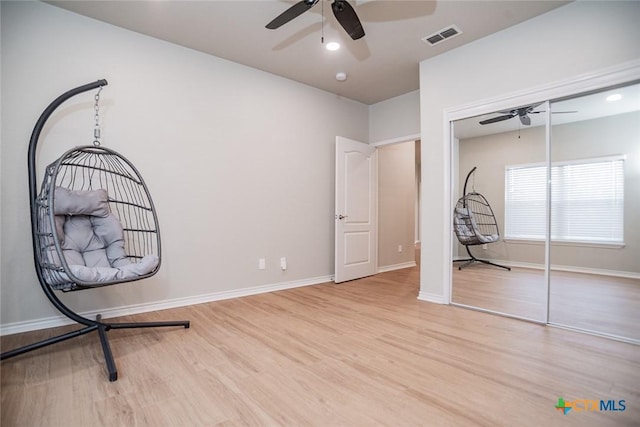 unfurnished bedroom with visible vents, wood finished floors, a closet, baseboards, and ceiling fan