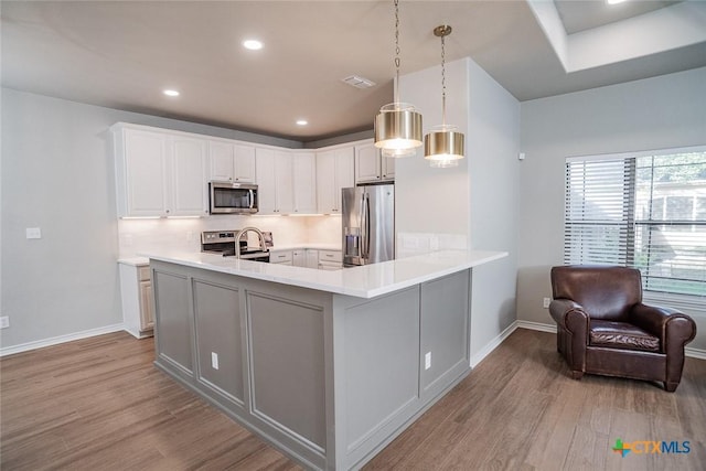 kitchen with tasteful backsplash, light wood-style floors, visible vents, and appliances with stainless steel finishes