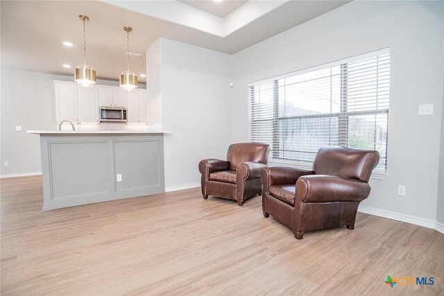 living area with recessed lighting, baseboards, and light wood finished floors