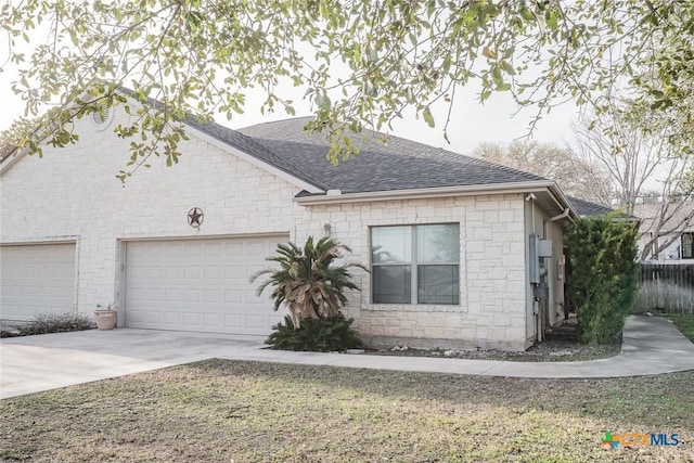 view of front facade featuring driveway, an attached garage, roof with shingles, and fence