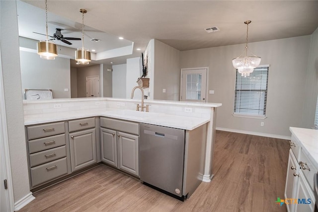 kitchen featuring visible vents, light wood finished floors, gray cabinets, a sink, and stainless steel dishwasher