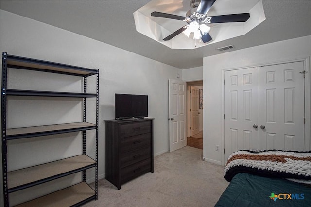 bedroom featuring baseboards, visible vents, light colored carpet, ceiling fan, and a closet