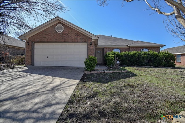 ranch-style house with a garage, a front yard, concrete driveway, and brick siding