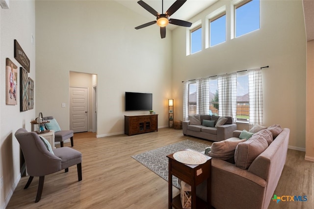 3301 Amerigo Pl, Round Rock, TX 78665 - living room featuring a high ceiling, a ceiling fan, baseboards, and light wood-style floors