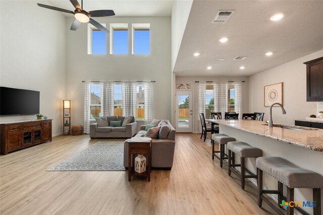 3301 Amerigo Pl, Round Rock, TX 78665 - living area featuring light wood-style flooring, recessed lighting, ceiling fan, a high ceiling, and baseboards