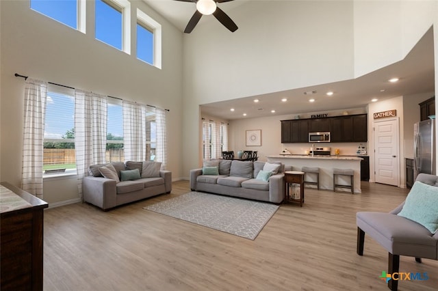 3301 Amerigo Pl, Round Rock, TX 78665 - living area with ceiling fan, a high ceiling, light wood-style floors, baseboards, and recessed lighting