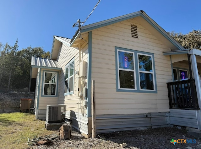 view of property exterior featuring central AC and a lawn