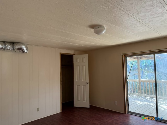 interior space featuring dark hardwood / wood-style flooring, access to outside, and a textured ceiling