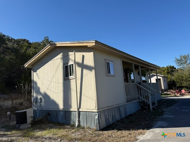 view of property exterior with a porch and central air condition unit