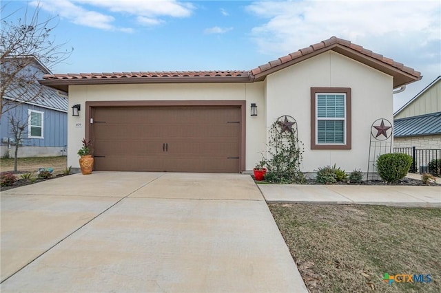 view of front facade featuring an attached garage, a tile roof, concrete driveway, and stucco siding