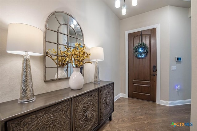 entrance foyer featuring dark wood finished floors and baseboards