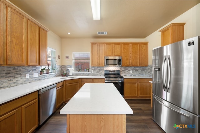 3416 Winding Shore Ln, Pflugerville, TX 78660 - kitchen featuring appliances with stainless steel finishes, light countertops, a center island, dark wood-style flooring, and recessed lighting
