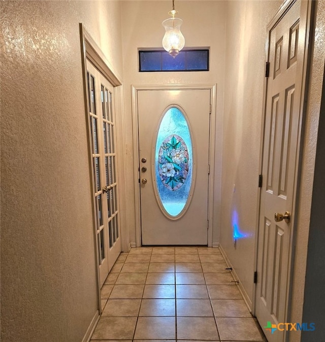 doorway to outside with light tile patterned floors