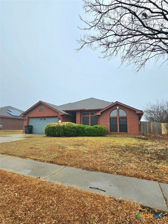 ranch-style house featuring a garage and a front yard