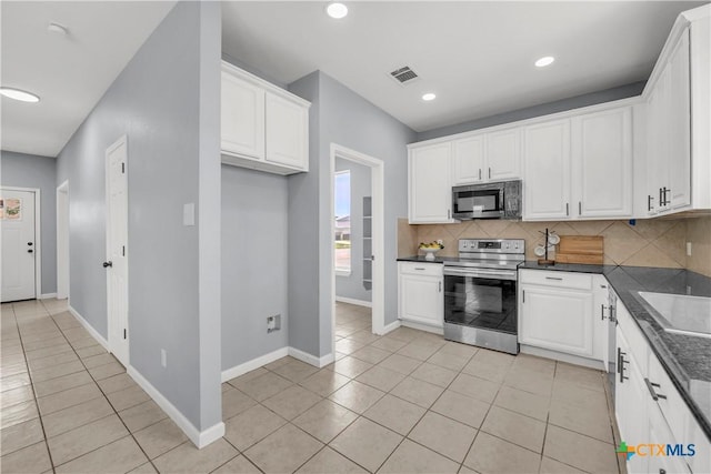 508 Taurus Dr, Killeen, TX 76542 - kitchen with stainless steel range with electric stovetop, dark countertops, light tile patterned floors, backsplash, and white cabinets