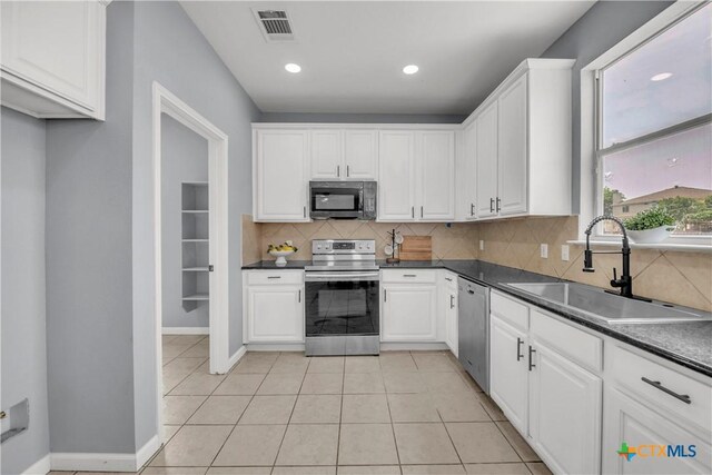 508 Taurus Dr, Killeen, TX 76542 - kitchen with stainless steel appliances, a sink, dark countertops, decorative backsplash, and white cabinetry