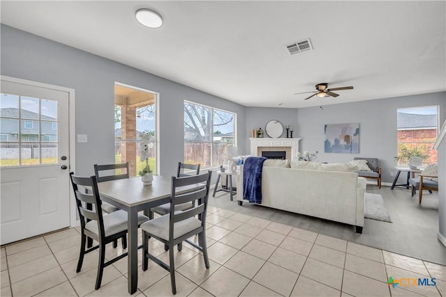 508 Taurus Dr, Killeen, TX 76542 - dining room featuring light tile patterned floors, a ceiling fan, and a fireplace