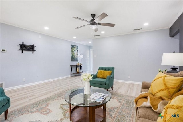 living area with baseboards, visible vents, ornamental molding, light wood-type flooring, and recessed lighting