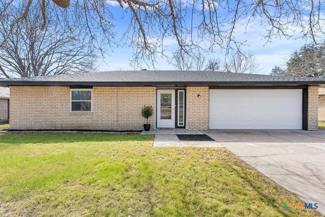 view of front facade featuring a garage, concrete driveway, a front lawn, and brick siding