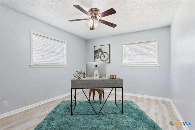 office space featuring a textured ceiling, light wood finished floors, and baseboards